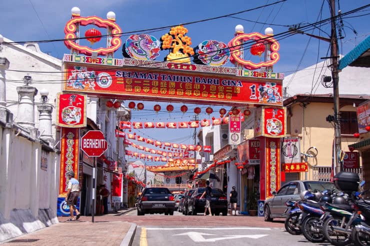 Kleurrijk Chinees nieuwjaarsfeest in Maleisië met traditionele rode lanterns en festivalelementen in een straat vol culturele decoraties.