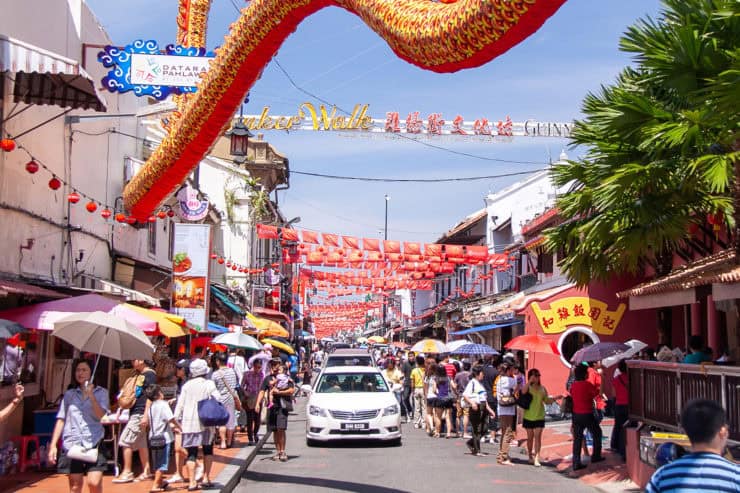 Leuk straatbeeld tijdens Chinese Nieuwjaarsviering op Jalan Petaling in Kuala Lumpur, Maleisië, met kleurrijke lampions, drukke marktkramen en toeristen die genieten van het culturele feest.