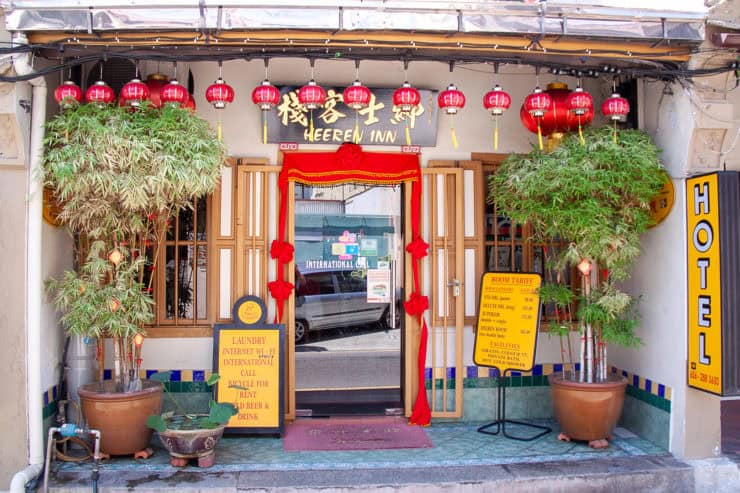 Kleurrijk Chinaas tinten hotel ingang met rode lampionnen, planten en uitnodigende entree.