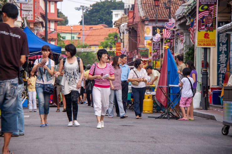 Gezellige straatmarkt in Maleisië met lokale winkels, kleurrijke tapas en bezoekers die genieten van de culturele sfeer.