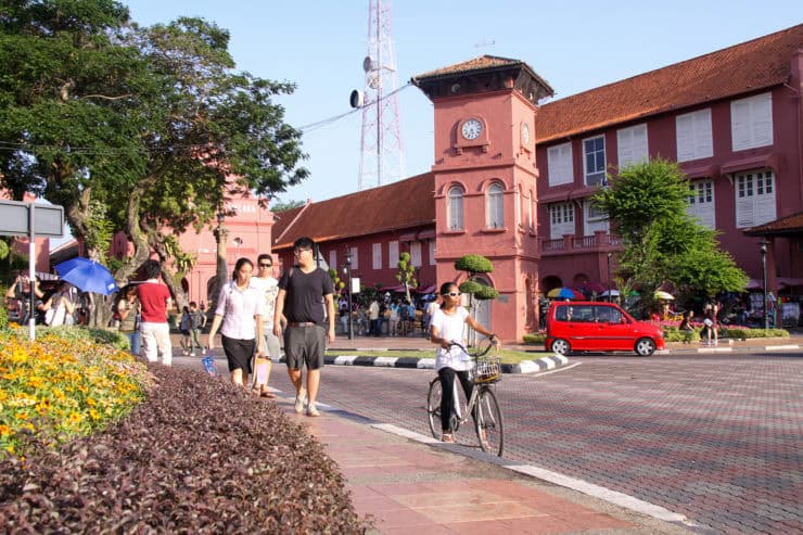 Kleurrijke straat met historische gebouwen in Malakka, Maleisië, vol met toeristen en fietsers, weerspiegeld de rijke cultuur en veelzijdigheid van Maleisië als toeristische bestemming.