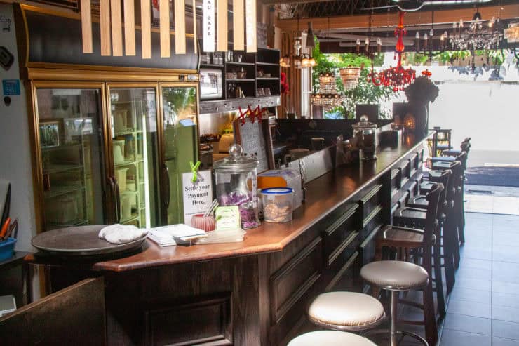 Gezellige bar met warme houten details en sfeervolle verlichting in een tropisch restaurant in Maleisië, ideaal voor een ontspannen vakantie-ervaring.