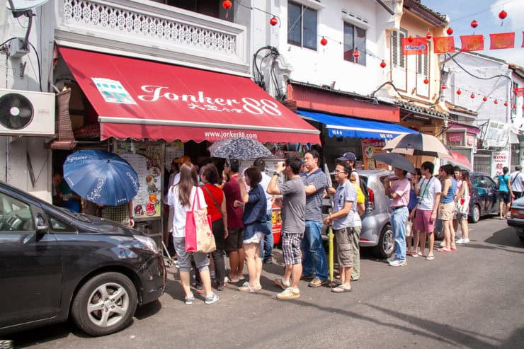 Drukke straat met mensen in rij voor eetkraam in Chinatown, Kuala Lumpur, Maleisië.
