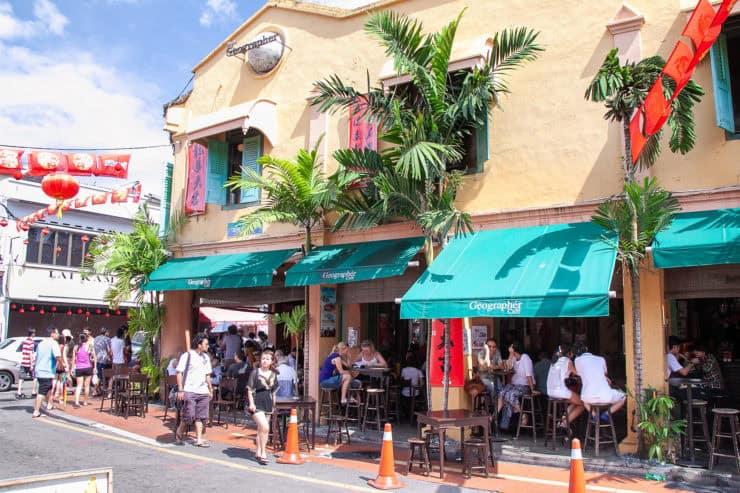 Kleurrijk straatbeeld met gezellige cafés en levendige sfeer in een populaire toeristische wijk in Maleisië.