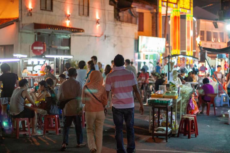 Gezellige straatmarkt in Maleisië met kleurrijke lichten, lokale eetkraampjes en inwoners die genieten van de avond. Een levendige cultuur vol straatleven en culinaire genoegens.