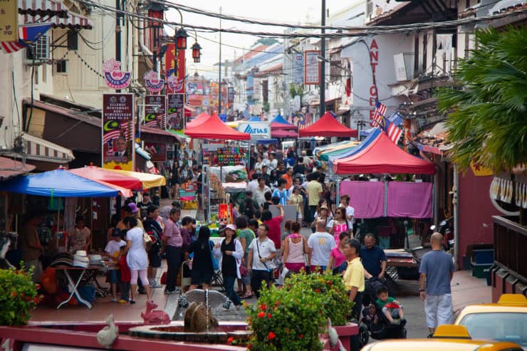 Kleurrijke straatmarkt in Maleisië met talloze stalletjes, lokale bewoners en toeristen, levendige sfeer, diverse producten, en traditionele en moderne invloeden, perfect voor toeristen en cultuurliefhebbers.