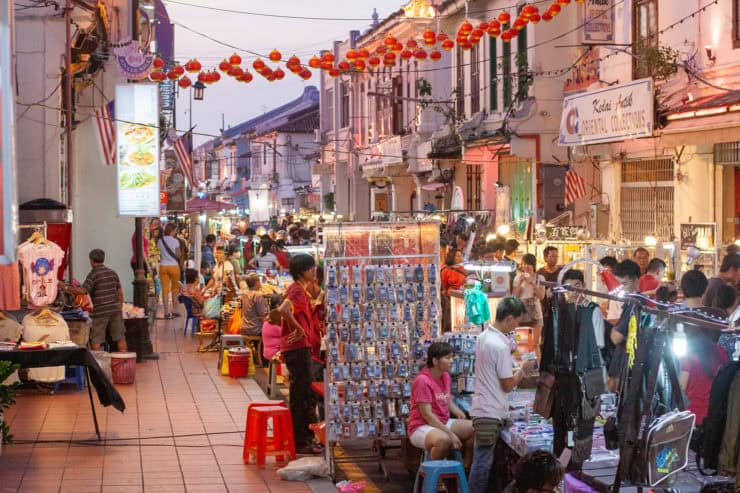 Heerlijke straatmarkt in Maleisië vol kleurrijke kleding, souvenirs en streetfood, levendige sfeer in een exotisch stadscentrum met traditionele lampionnen en druk verkeer.