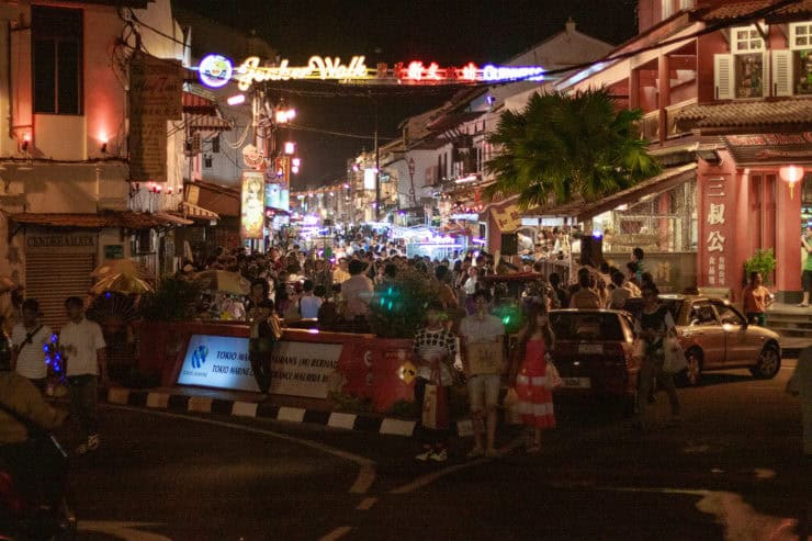 Blauw verlichte straat vol levendige mensen, winkels en restaurants op night market in Maleisië, gezellige sfeer, kleurrijke neonlichten en toeristen genieten van avond uit in Kuala Lumpur.