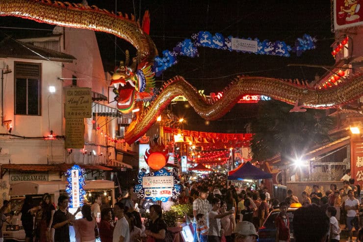 Vivid straatpunt in Maleisië met kleurrijke Chinese drakenlampionnen, drukke menigte en feestelijke verlichting tijdens Chinese Nieuwjaar in Chinatown.