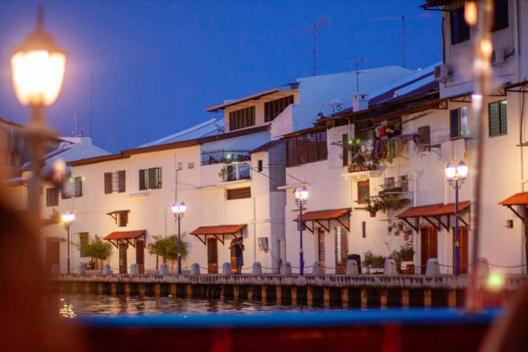 Gezellige sfeer aan de waterkant in Maleisië tijdens de avond, met traditionele gebouwen, sfeerverlichting en rustige omgeving voor een authentieke reiservaring.