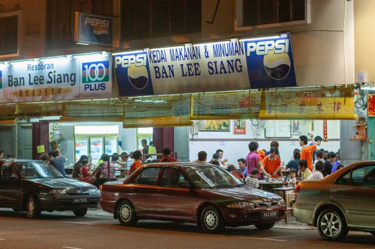 Gezellige nachtmarkthal in Maleisië met eetkraampjes en auto’s, populaire plek voor lokale gerechten en streetfood, kleurrijk en levendig sfeer.