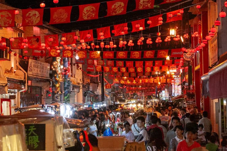 Kleurrijke avondmarkt in Maleisië met traditionele rode lantaarns en drukke menigte, perfect voor cultuurreis en streetfood ontdekken.